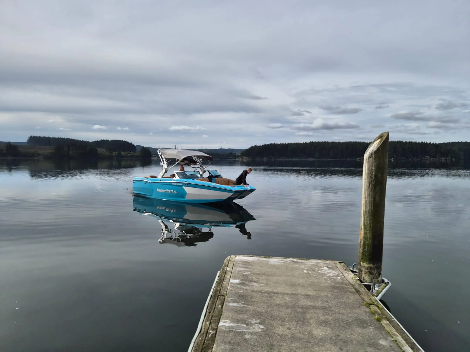 Wake boat beside the dock on Lake Maraetai