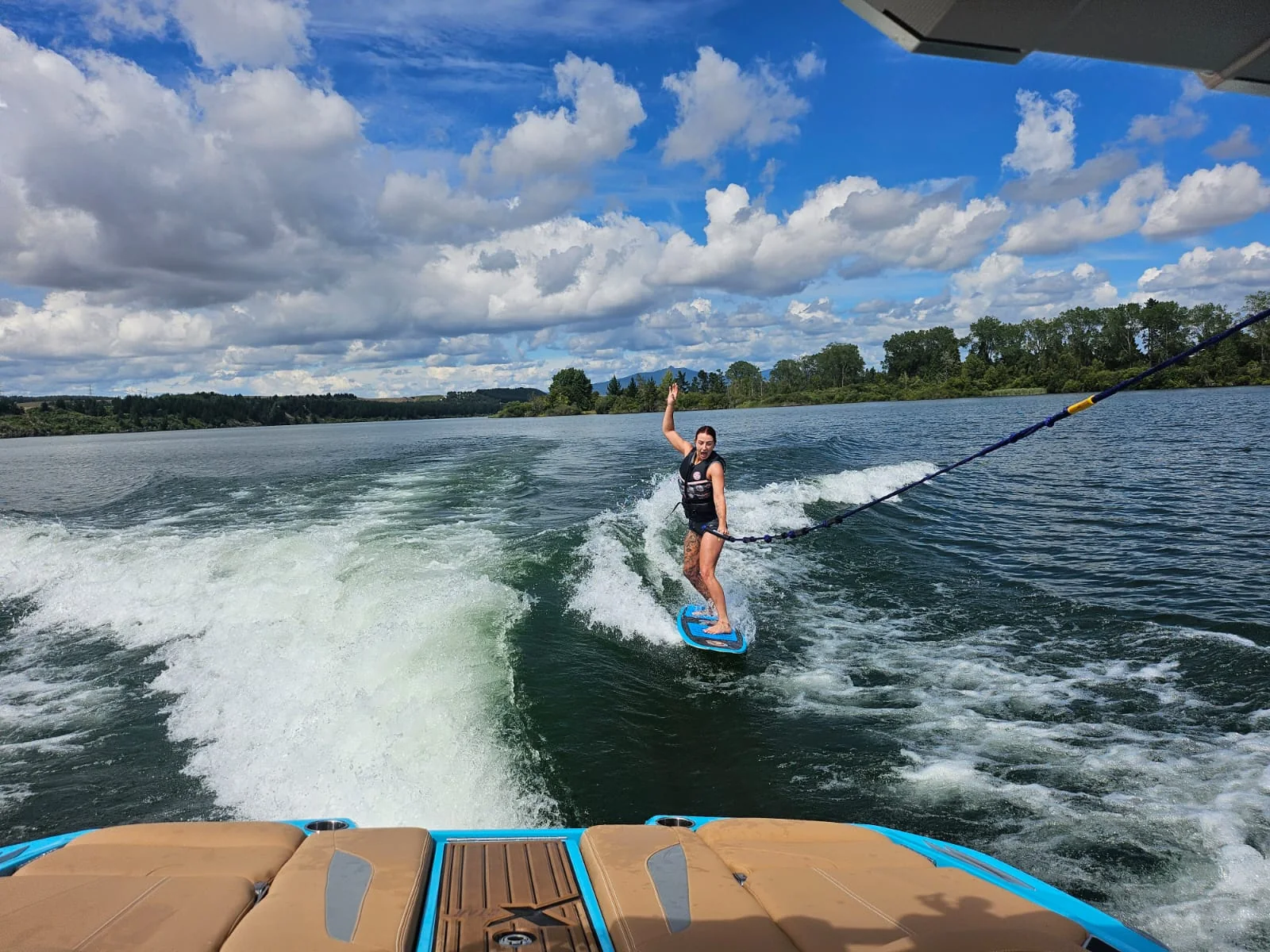 Wakesurfer with a blue board following the wake